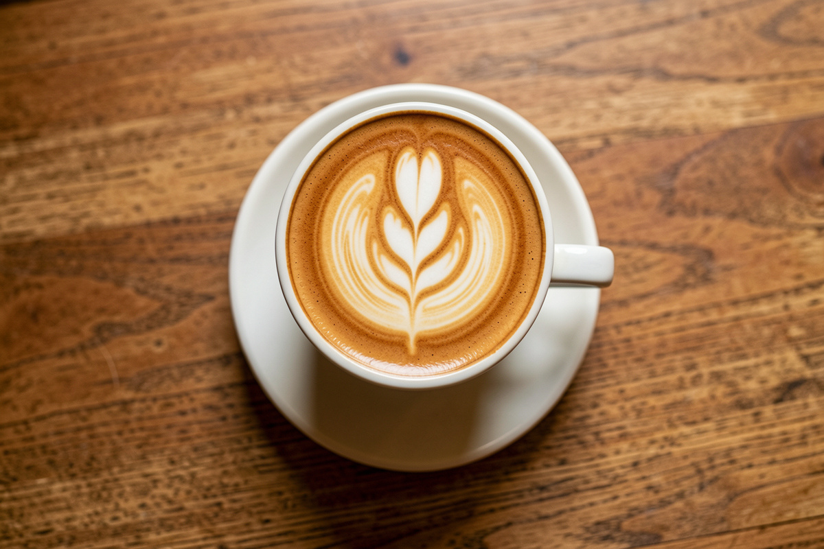 Latte art coffee cup on warm wooden table